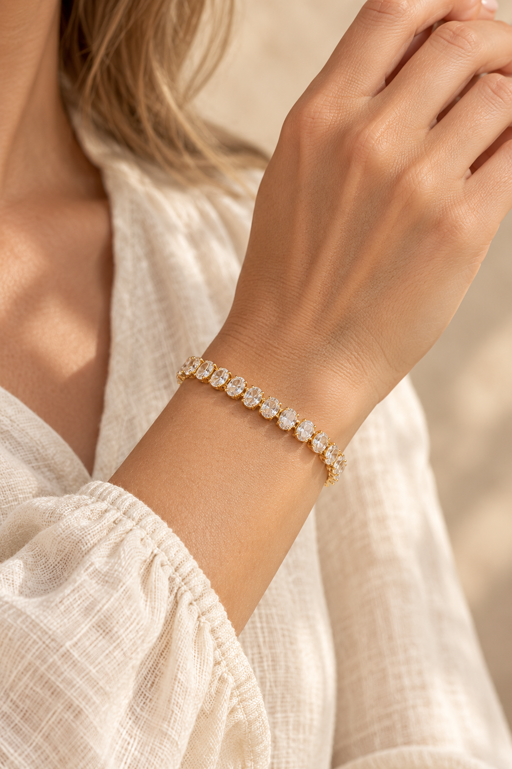 Aurora Oval Crystal Gold Tennis Bracelet worn on a model's wrist