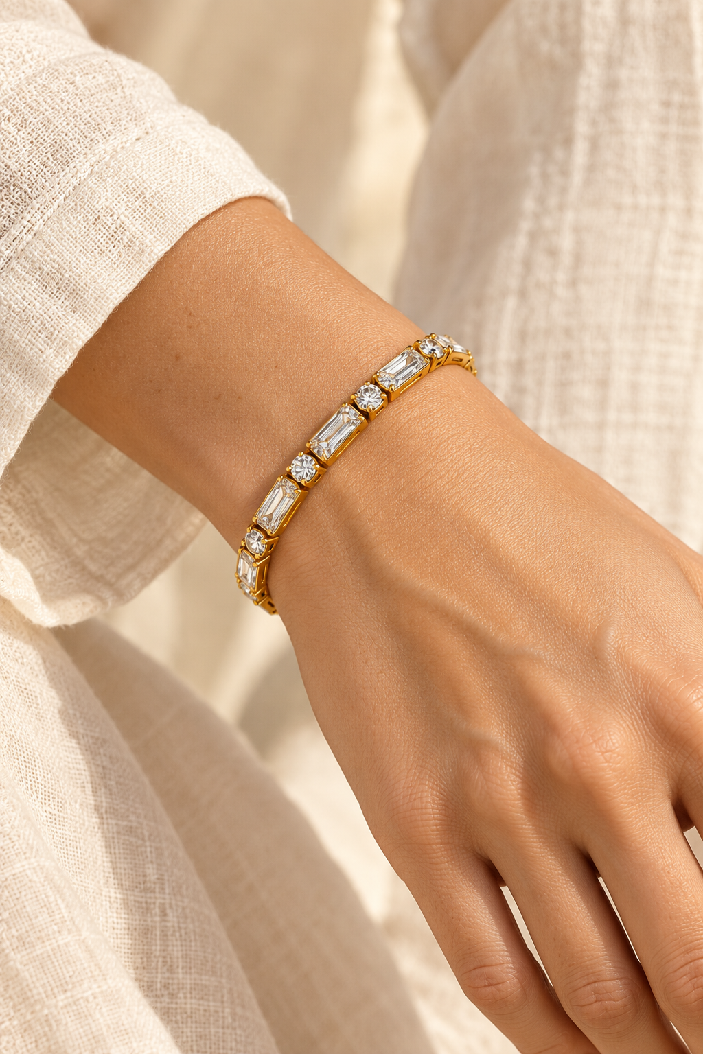 Avelisse Emerald & Round Crystal Gold Tennis Bracelet worn on a model's wrist