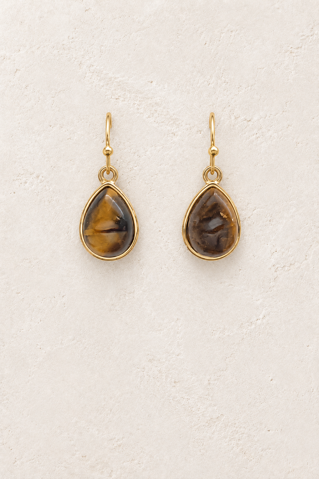 
                  
                    Aviana Tigers Eye Teardrop Earrings on cream plaster background
                  
                
