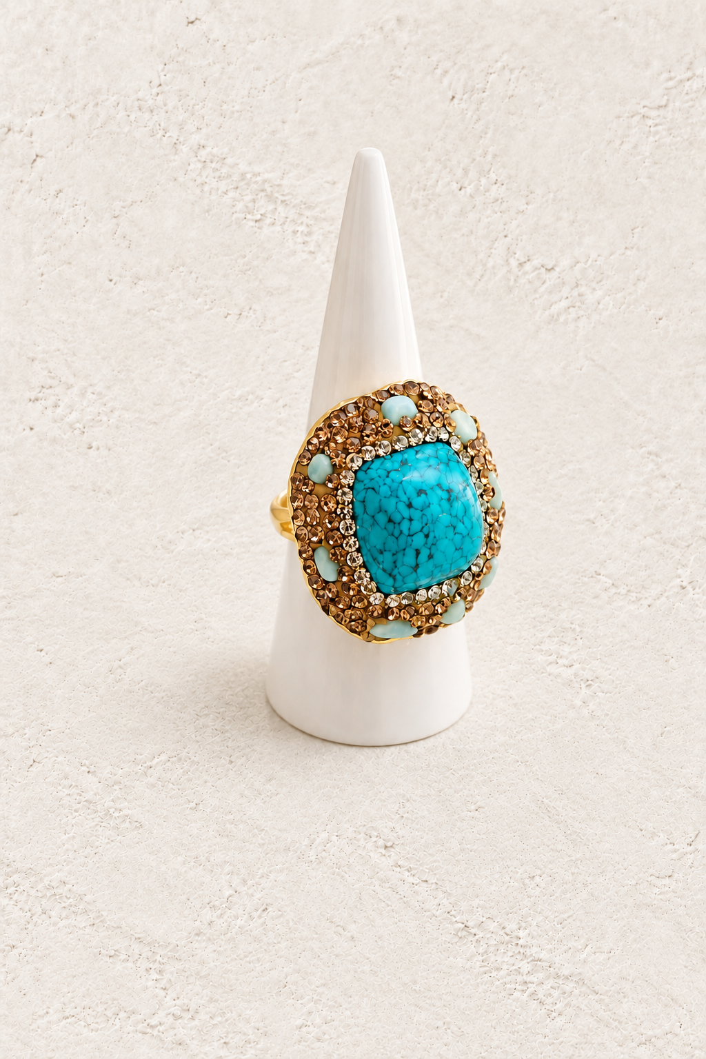 Azura Turquoise Ring on white cone against warm textured background