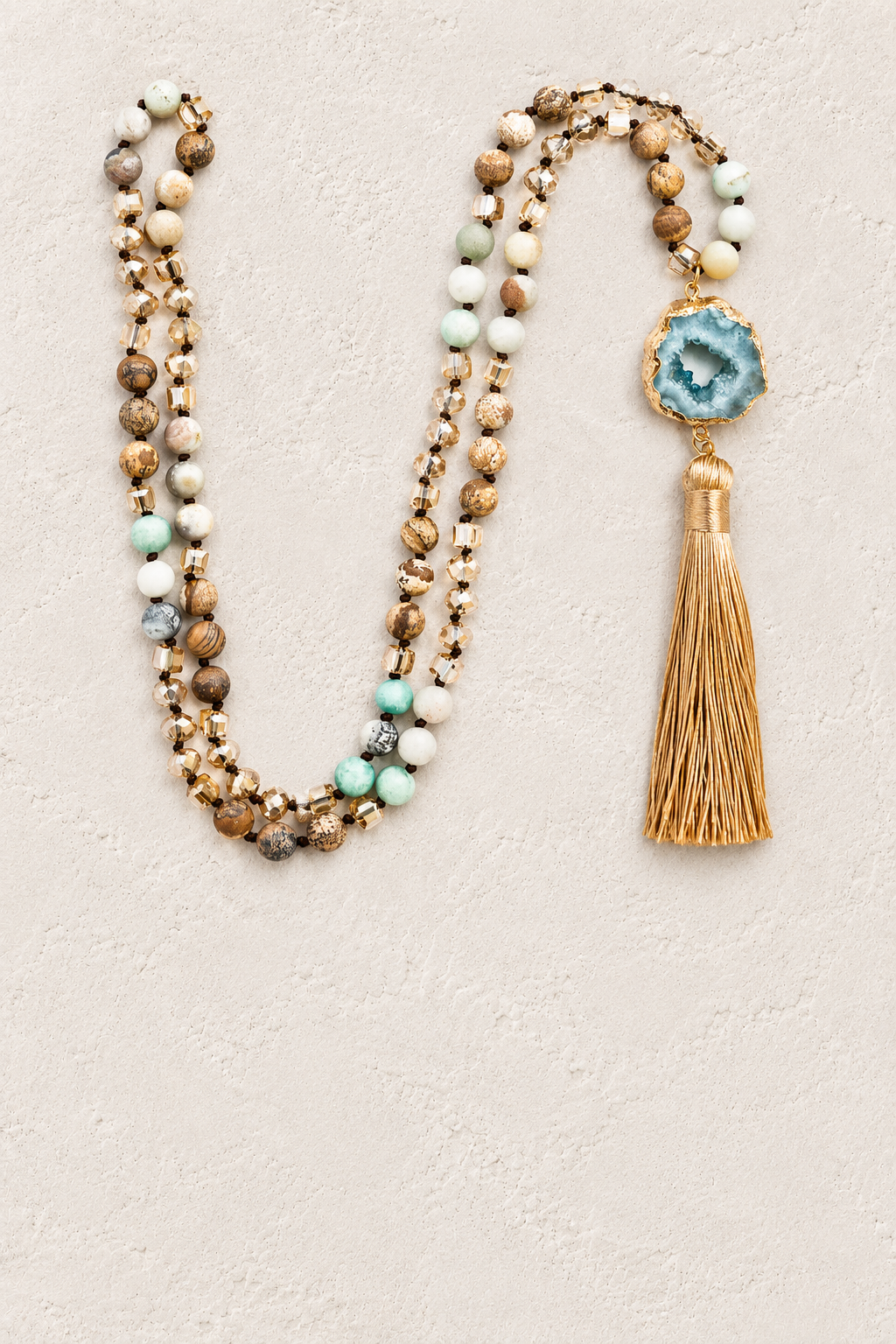 Beige Agate Slice Tassel Necklace on warm cream plaster background