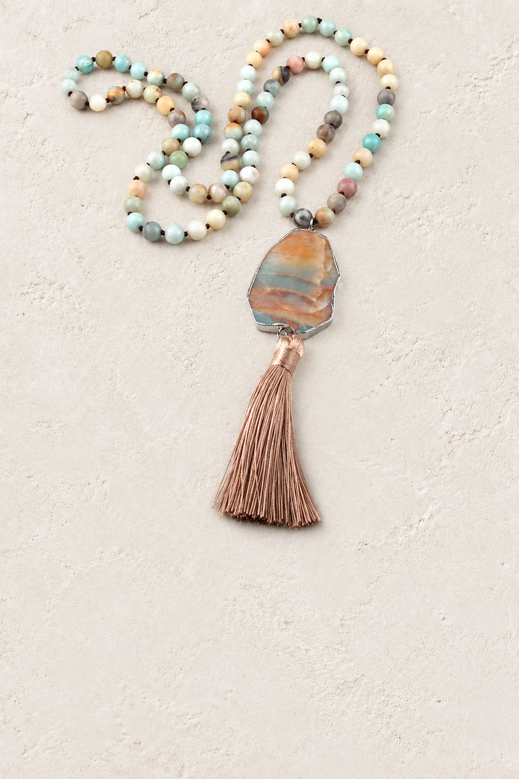 
                  
                    Blue Amazonite Tassel Necklace on warm ivory plaster background
                  
                