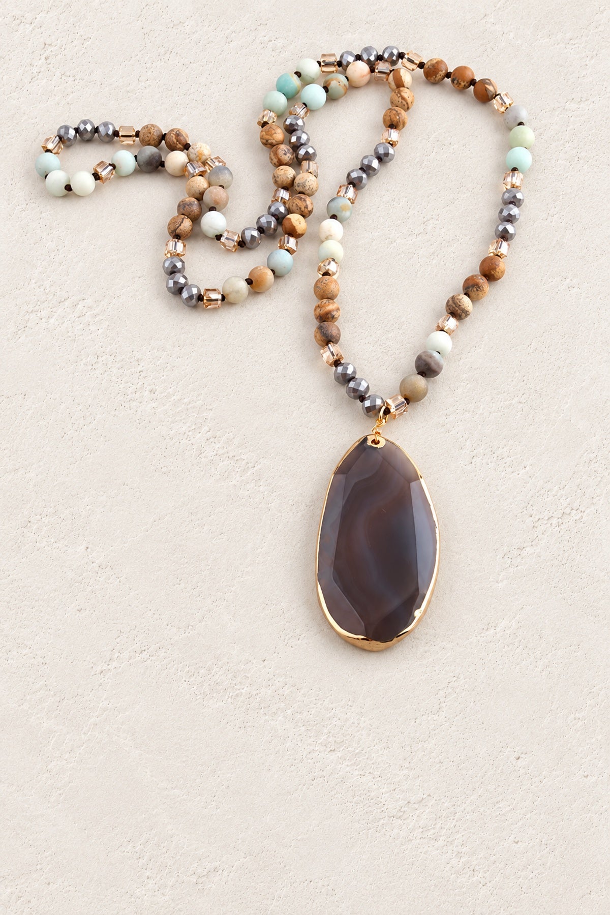 Blue Mixed Agate Tribal Necklace on warm cream plaster background