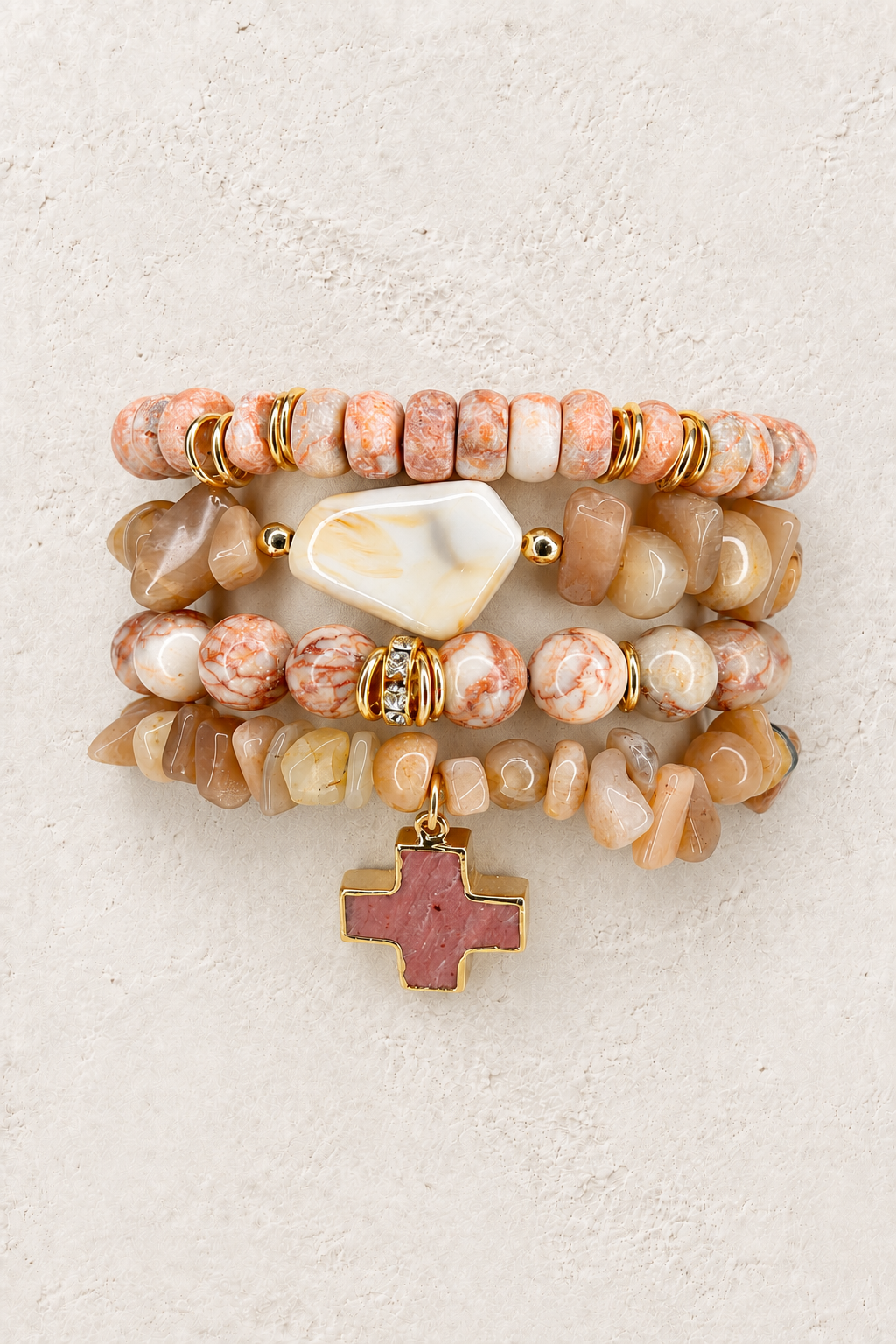 Blush Grace 4-piece elastic bracelet stack on warm textured background