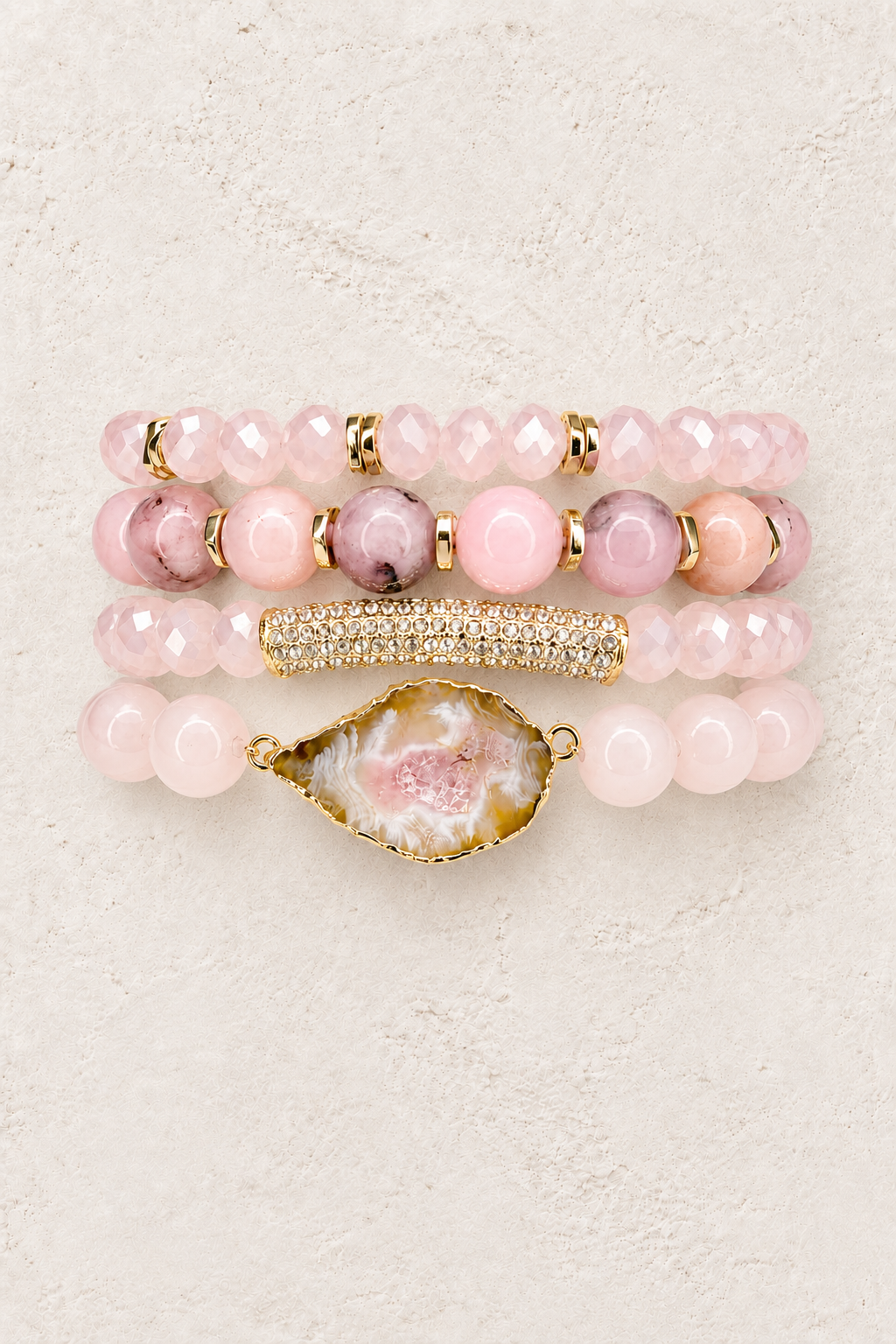 Blush Harmony 4-piece elastic bracelet stack on warm textured background