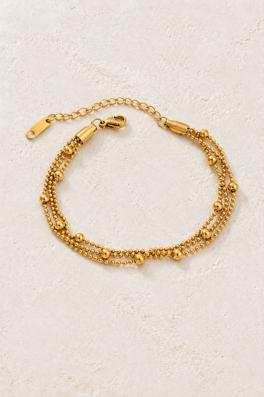 
                  
                    Gold Beaded Layered Bracelet on ivory stone
                  
                