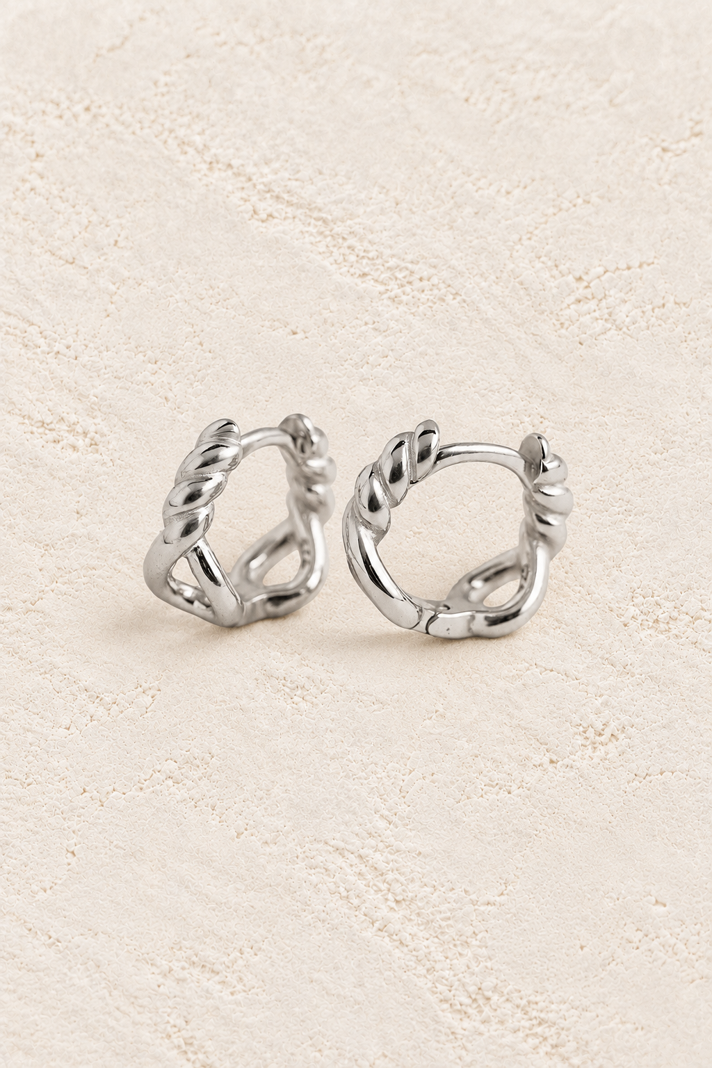 Chain Huggies Sterling Silver Hoop Earrings on warm cream textured background