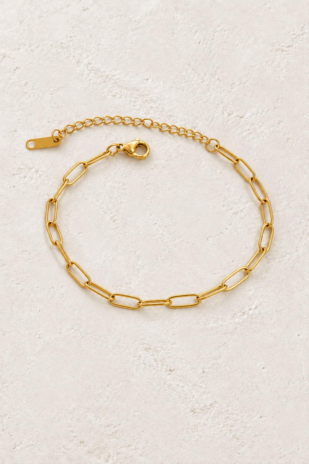 
                  
                    Gold Fine Paperclip Bracelet on ivory stone
                  
                