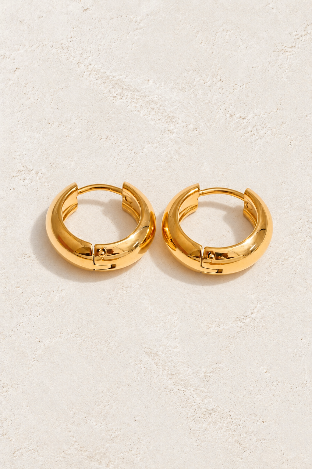 
                  
                    Classic gold waterproof hoop earrings — 10 mm on approved cream background
                  
                