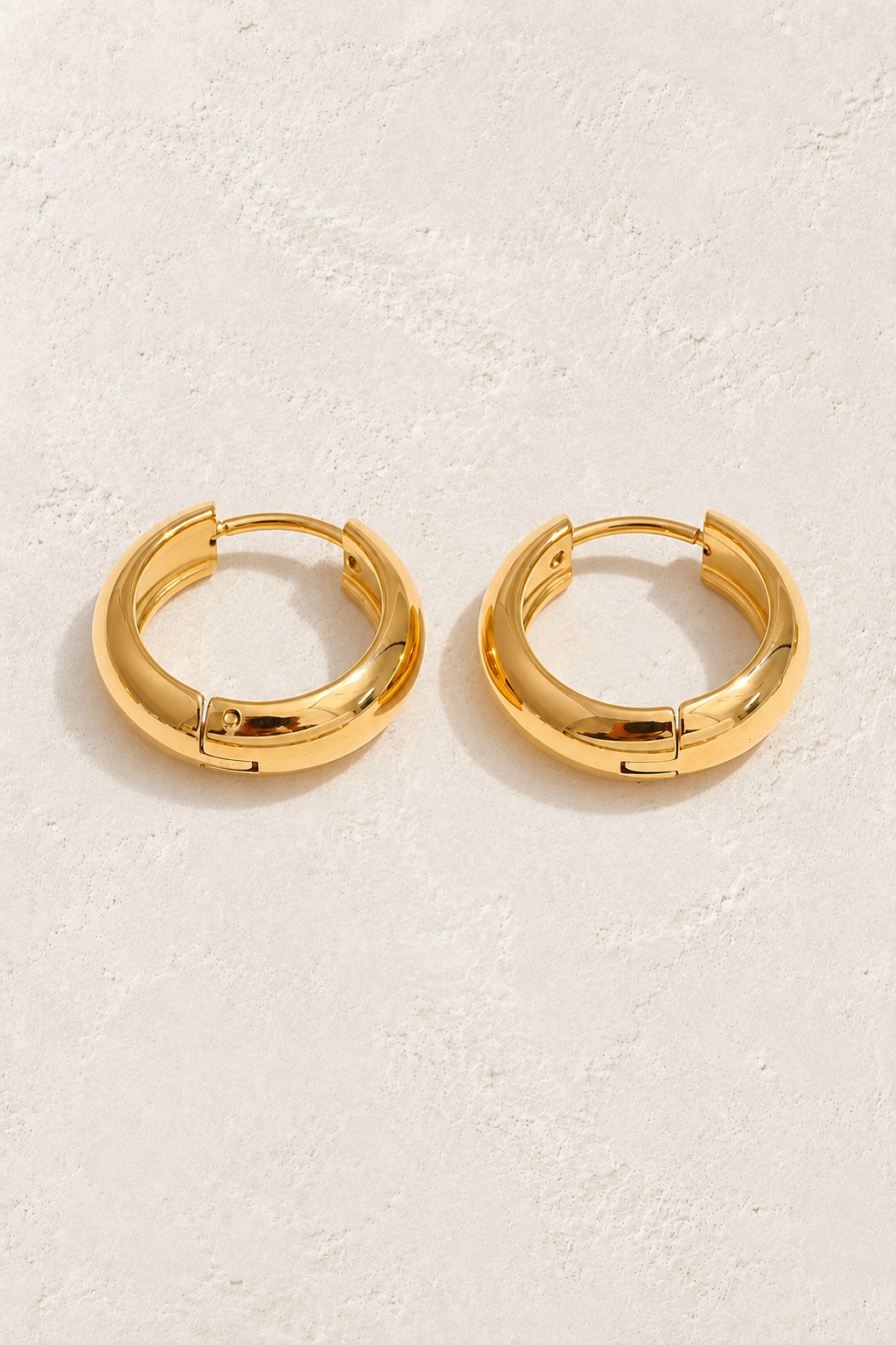 
                  
                    Classic gold waterproof hoop earrings — 12 mm on approved cream background
                  
                