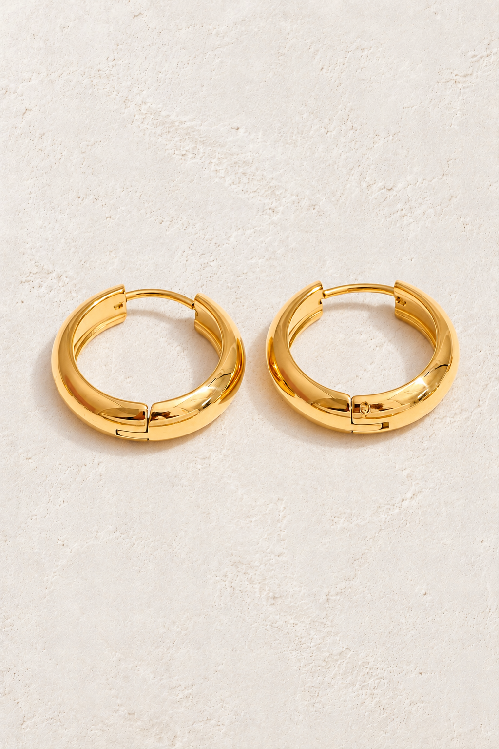 
                  
                    Classic gold waterproof hoop earrings — 16 mm on approved cream background
                  
                