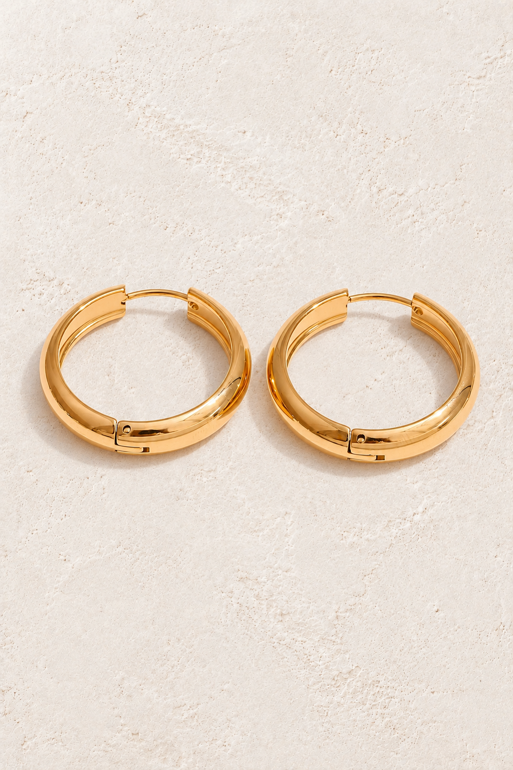 
                  
                    Classic gold waterproof hoop earrings — 20 mm on approved cream background
                  
                