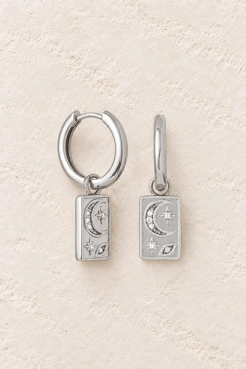 Boho & Mala Sterling Silver Hoop Huggie Earrings on warm cream textured background