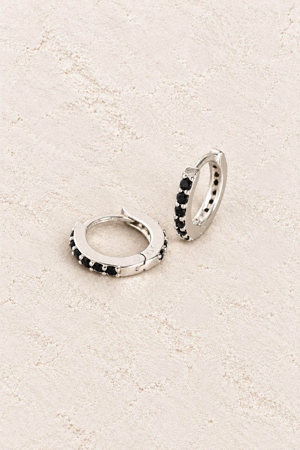 Boho & Mala Sterling Silver Hoop Huggie Earrings on warm cream textured background