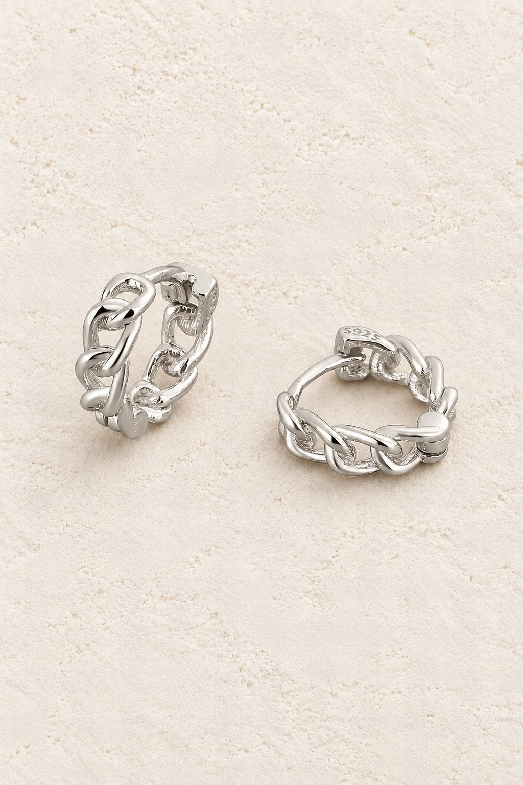 
                  
                    Boho & Mala Sterling Silver Hoop Huggie Earrings on warm cream textured background
                  
                