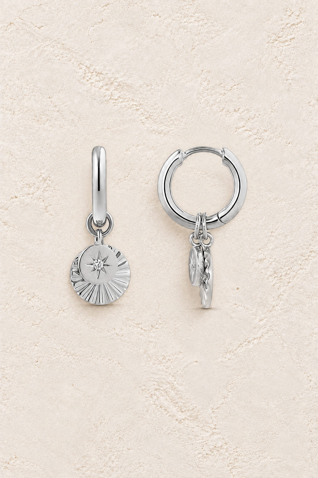 
                  
                    Boho & Mala Sterling Silver Hoop Huggie Earrings on warm cream textured background
                  
                