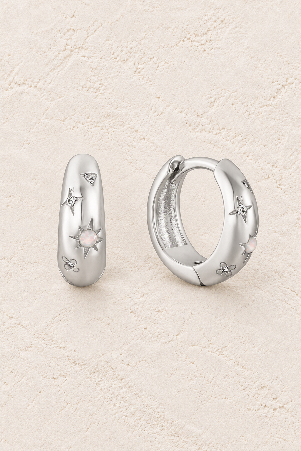 
                  
                    Boho & Mala Sterling Silver Hoop Huggie Earrings on warm cream textured background
                  
                