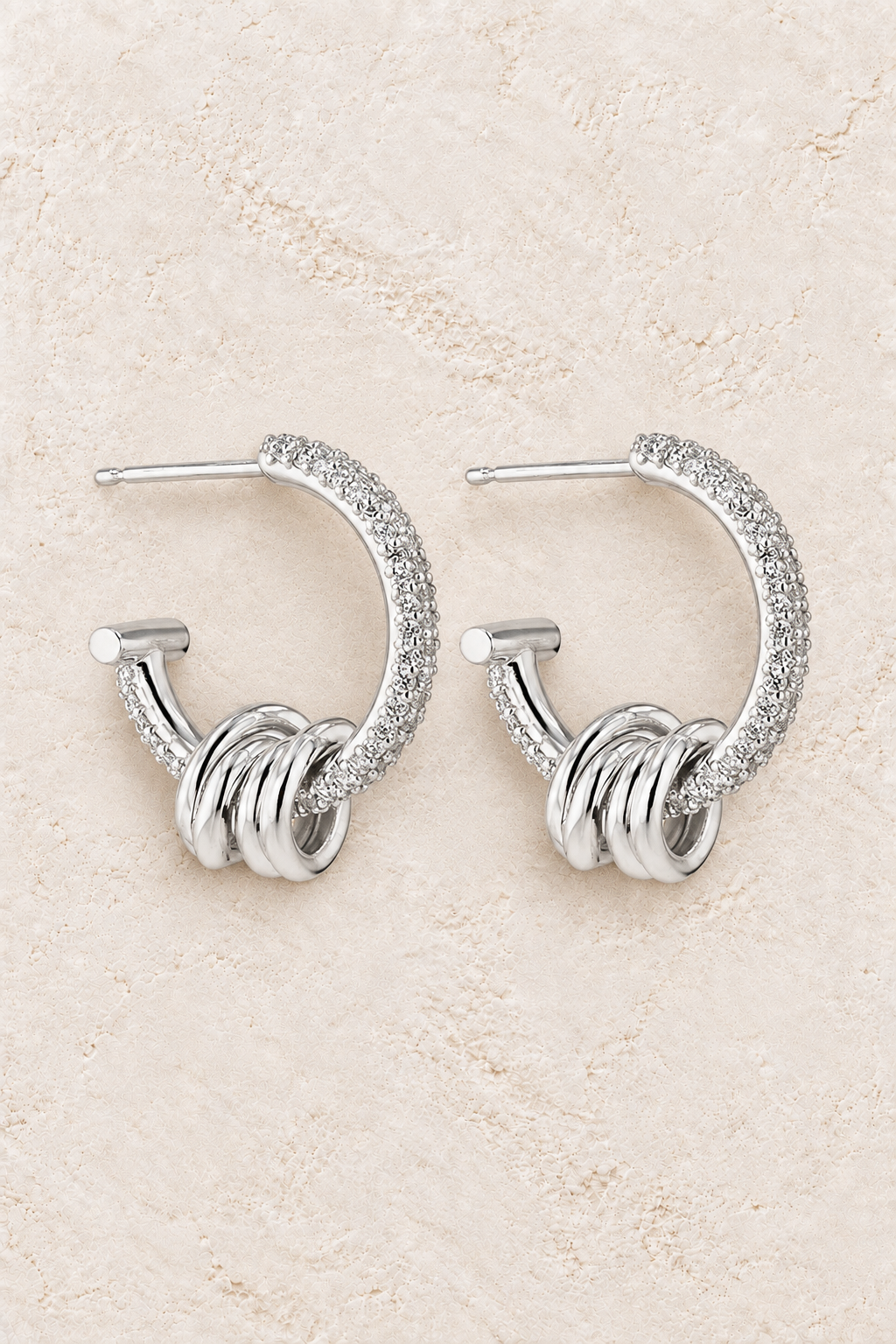 Boho & Mala Sterling Silver Hoop Huggie Earrings on warm cream textured background