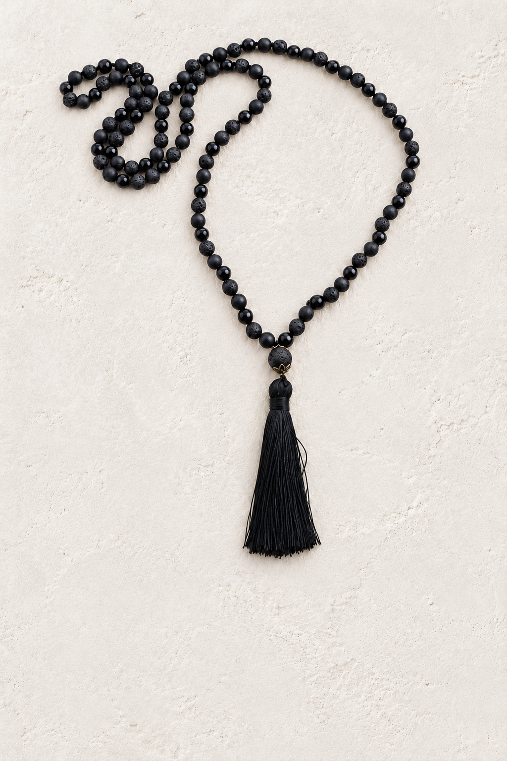 Black Tassel Mala Necklace on the Boho & Mala cream stone hero background