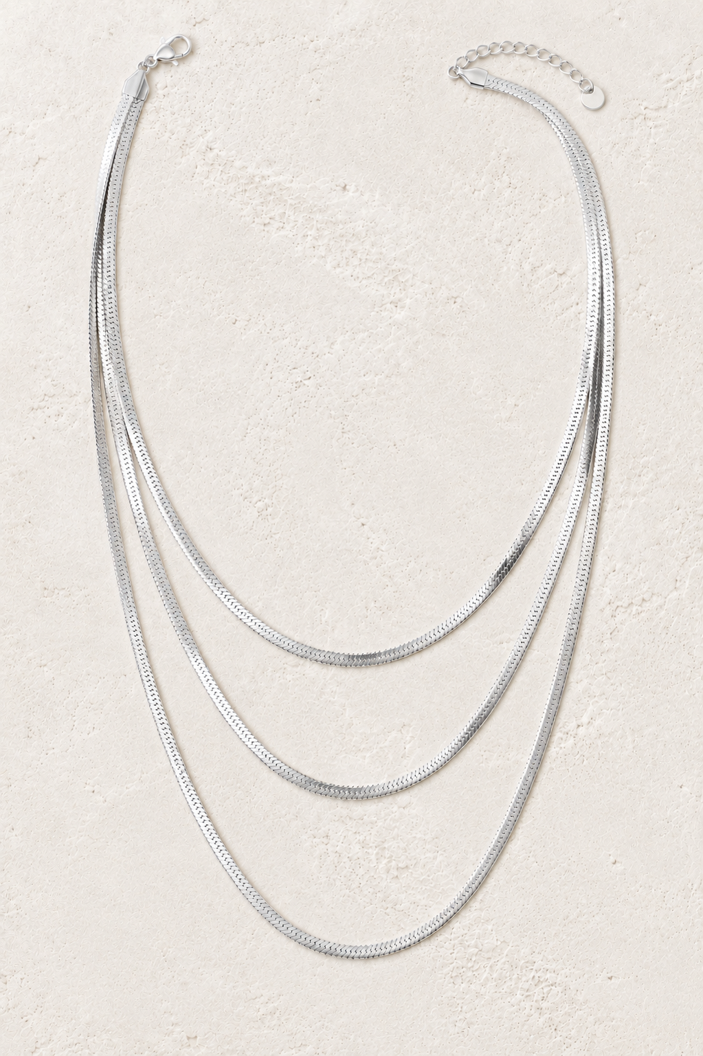 Sienna Silver Triple Layer Herringbone Necklace on the Boho & Mala cream stone hero background