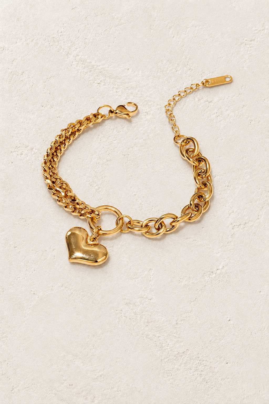 
                  
                    Coeur Gold Heart Chain Bracelet on ivory textured background
                  
                