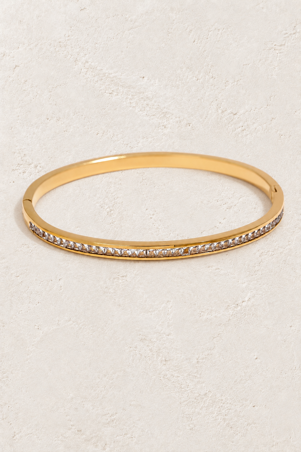 
                  
                    Serene Gold Clear Crystal Bangle on ivory textured background
                  
                