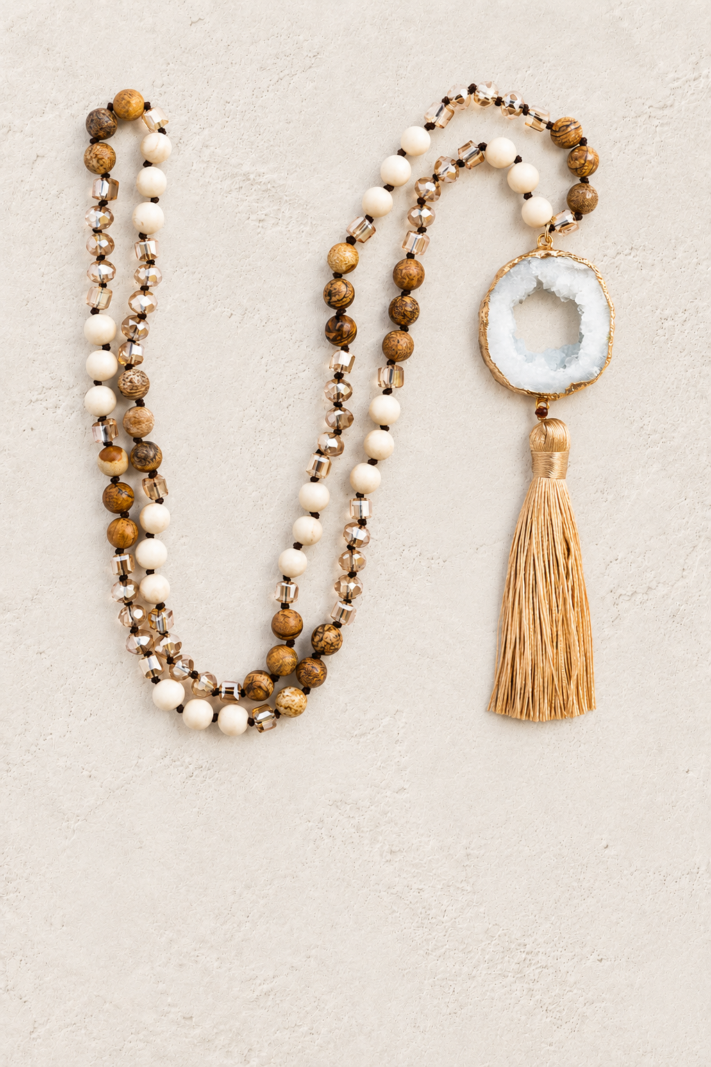Brown Mix Agate Slice Tassel Necklace on warm ivory plaster background