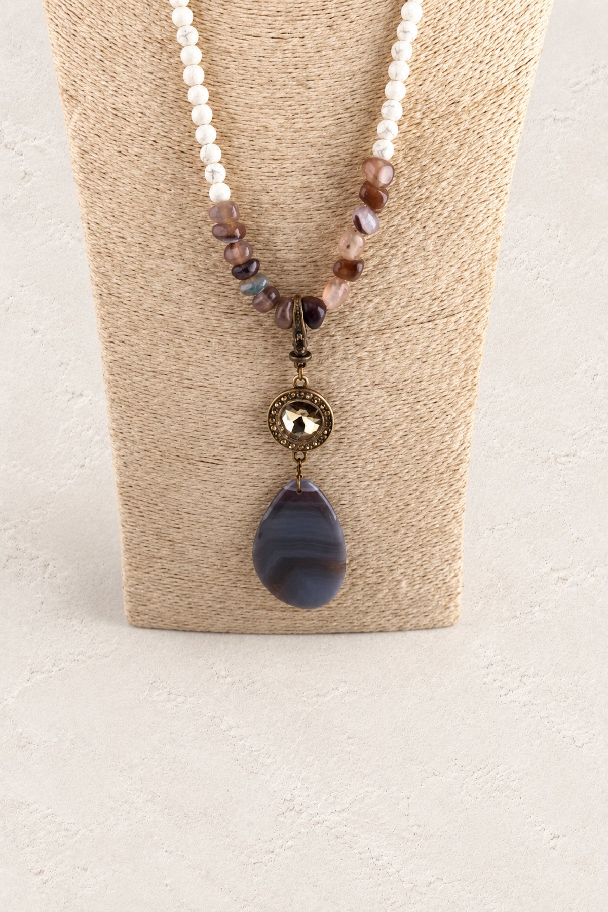 Brown Stone Tribal Teardrop Necklace on warm cream plaster background