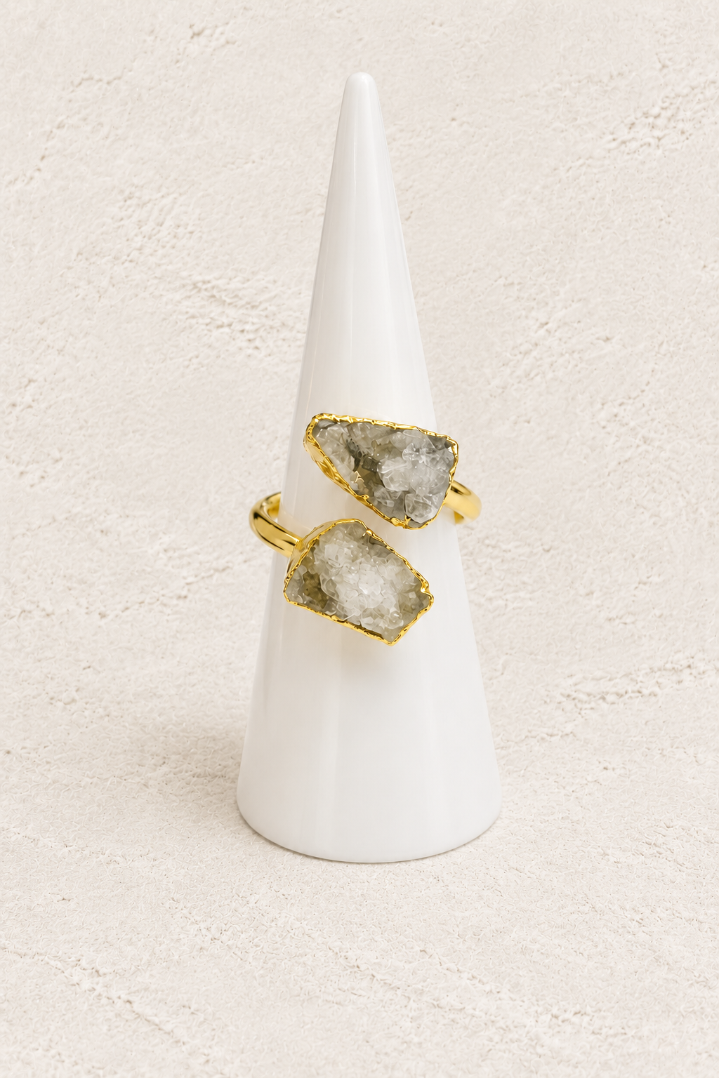 Celeste Druzy Adjustable Ring on white cone against warm textured background