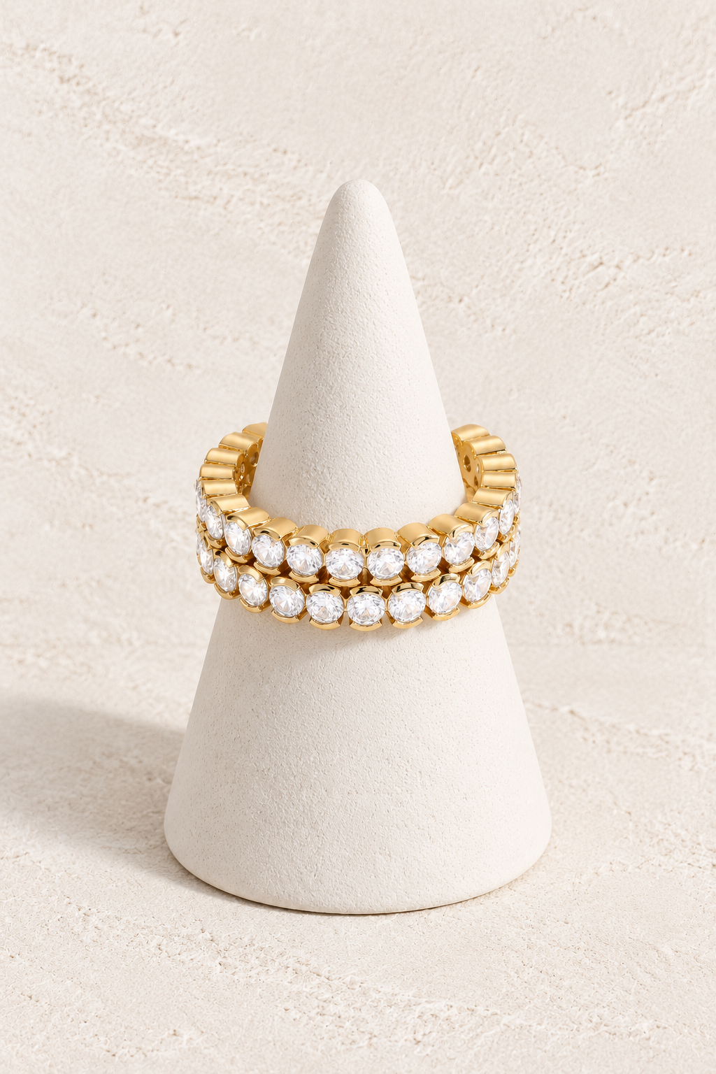 Celeste Glow Ring on a white display cone against a warm textured background