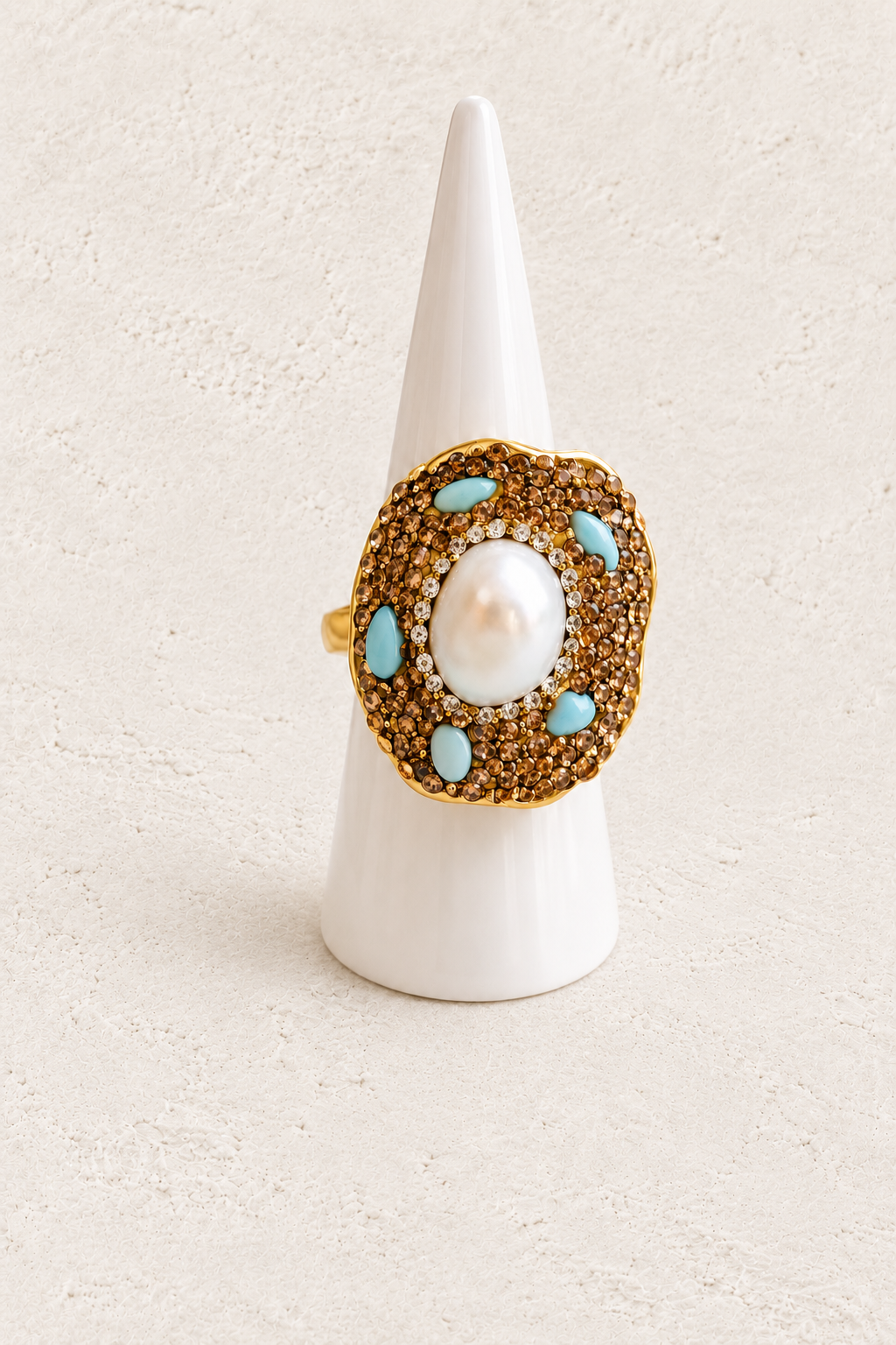 Celestia Amazonite & Freshwater Pearl Ring on white cone against warm textured background