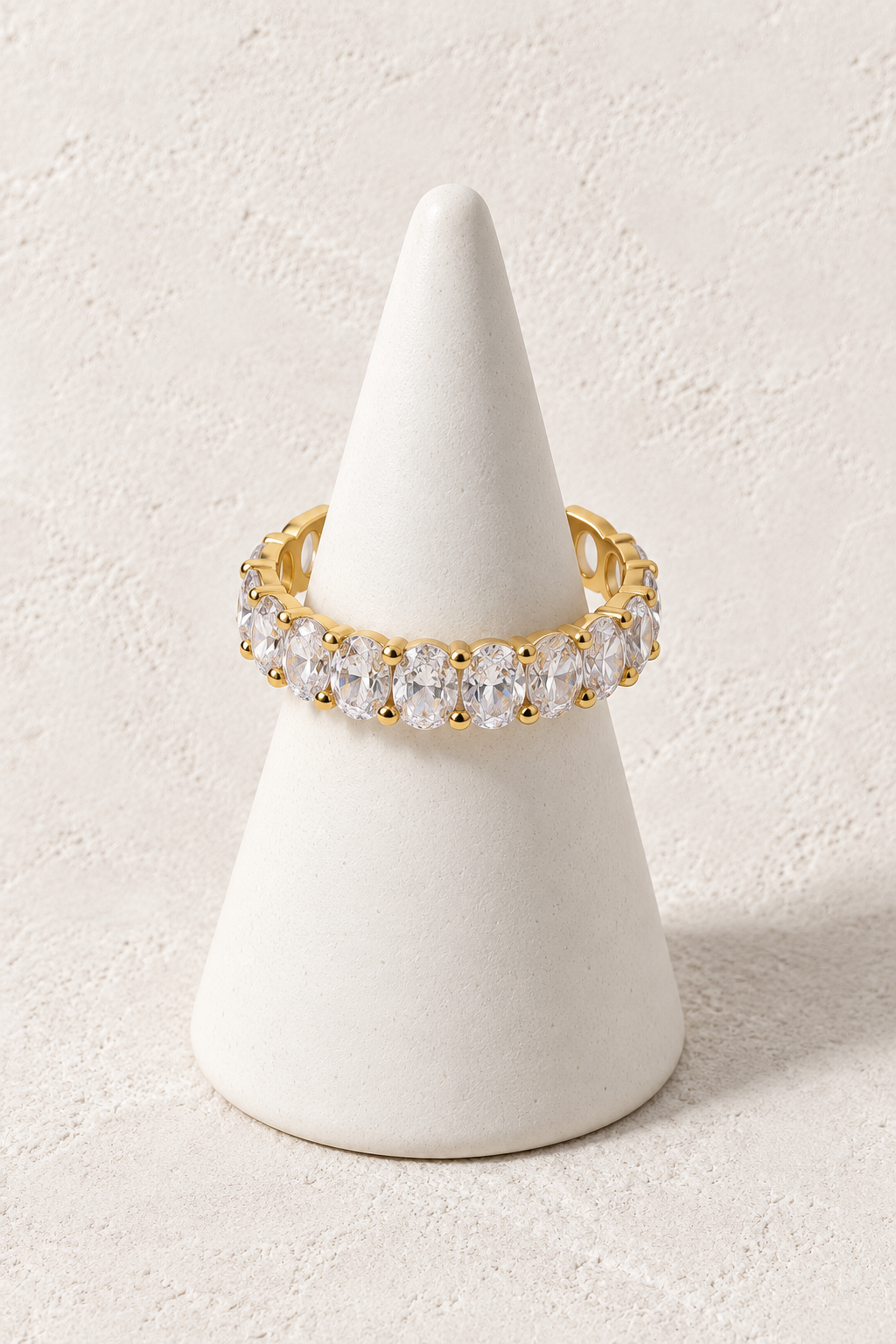 Celestial Crystal Ring on a white display cone against a warm textured background