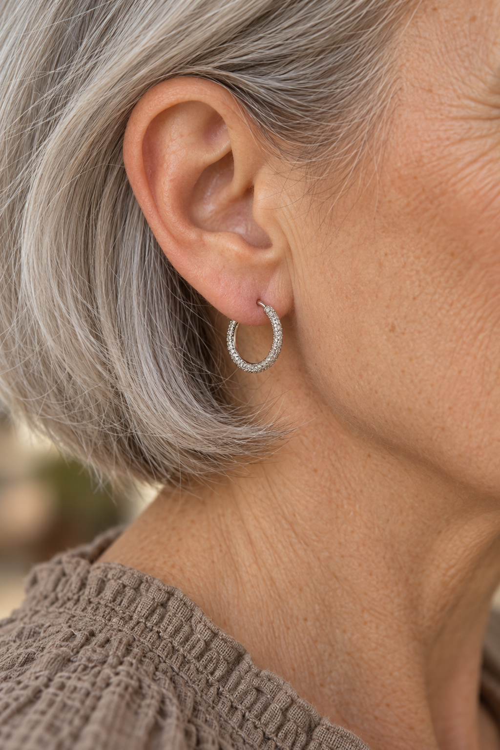 
                  
                    Close-up of Cielle Silver Shimmer Hoop Earrings worn on a boho chic model
                  
                