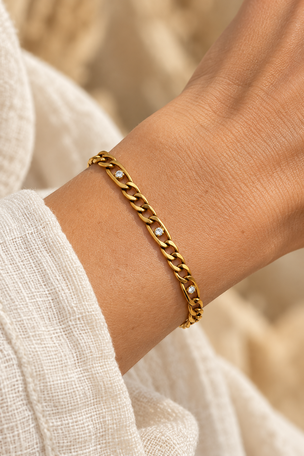 
                  
                    Clarisse Gold Crystal Figaro Bracelet worn on a model's wrist
                  
                