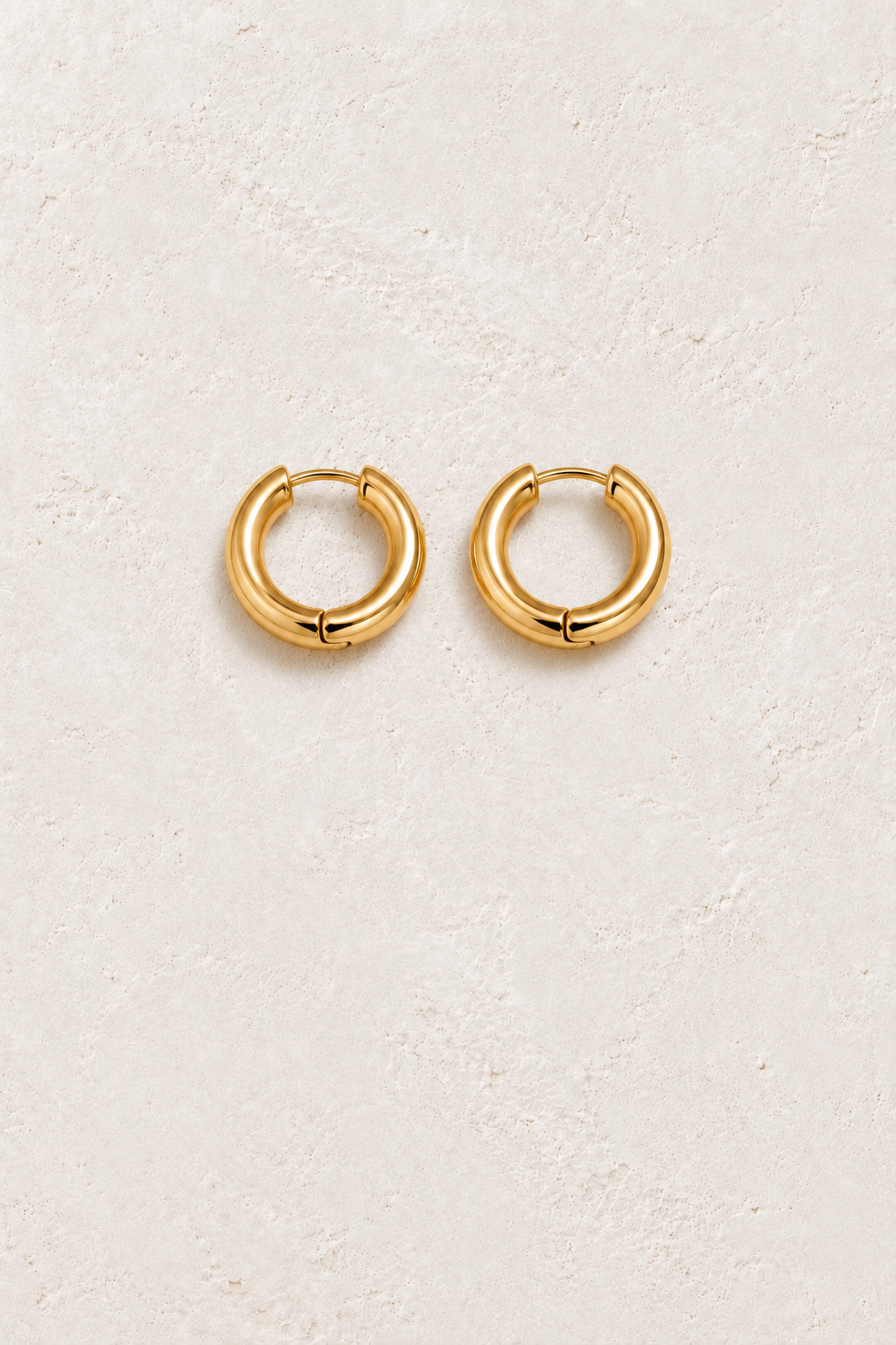 
                  
                    Gold 11mm Classic Waterproof Hoop Earrings on cream plaster background
                  
                