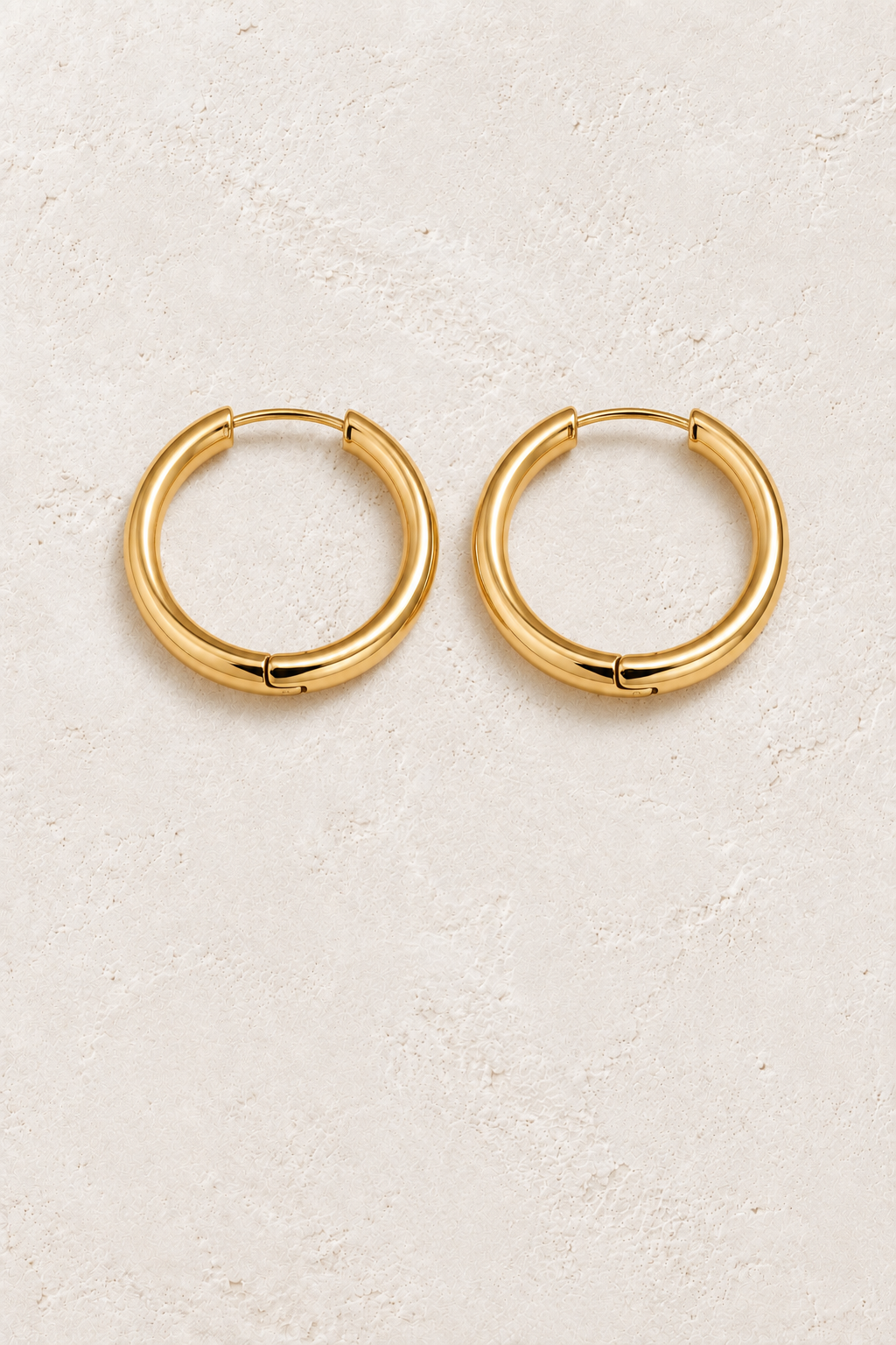 
                  
                    Gold 20mm Classic Waterproof Hoop Earrings on cream plaster background
                  
                