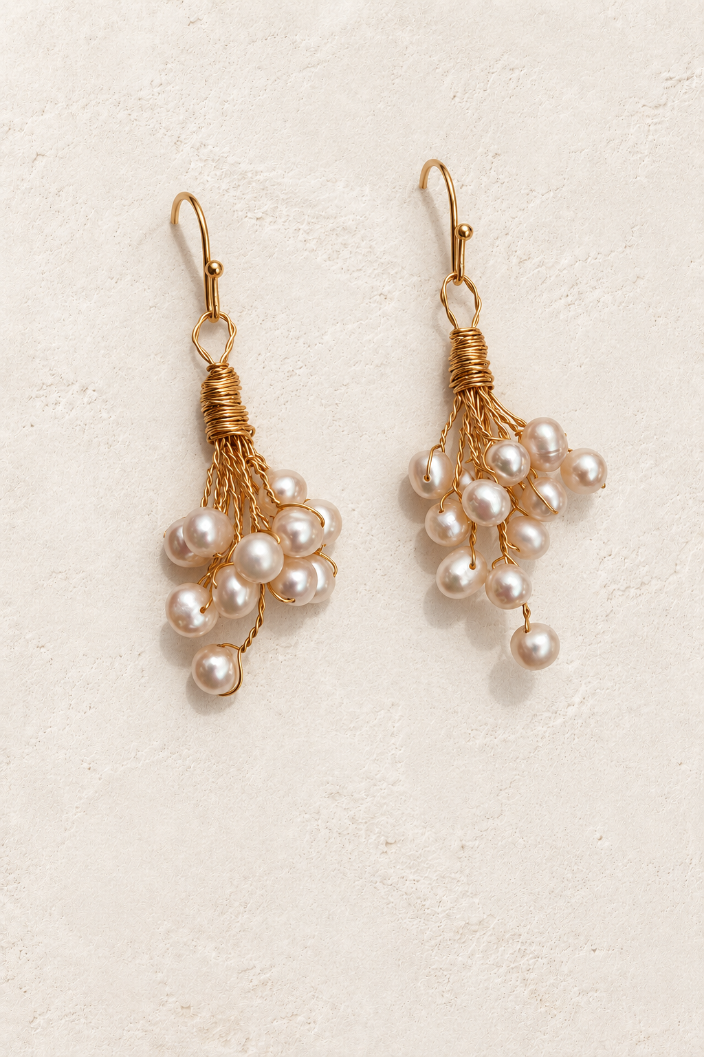 
                  
                    Cressida Gold Pearl Cluster Drop Earrings on cream plaster background
                  
                