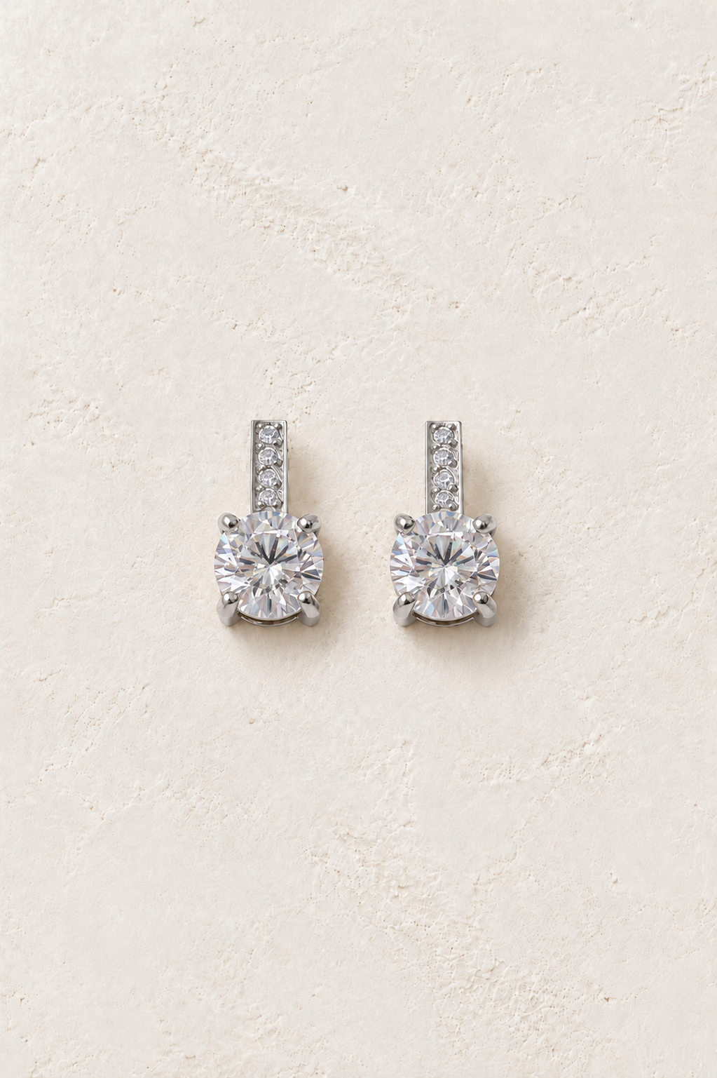
                  
                    Silver crystal bar solitaire stud earrings on ivory plaster
                  
                