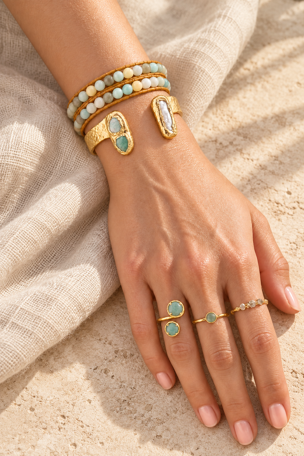 Boho & Mala amazonite wrap bracelet, gold amazonite and pearl cuffs and amazonite rings on linen