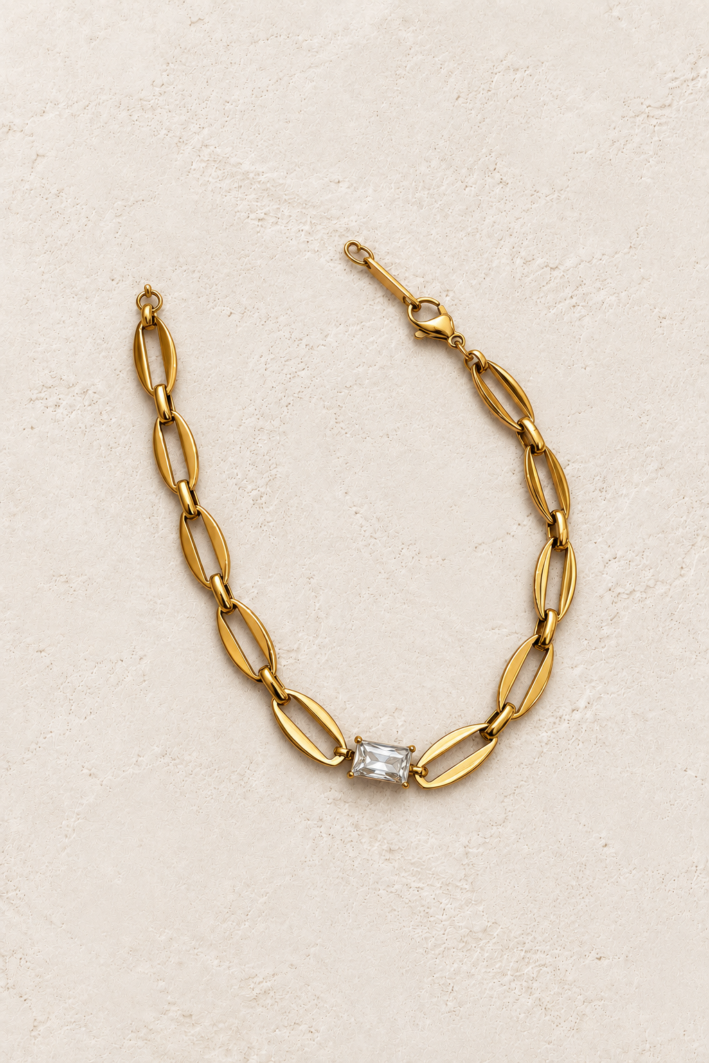 
                  
                    Delphine Gold Crystal Centre Link Bracelet on cream beige textured background
                  
                
