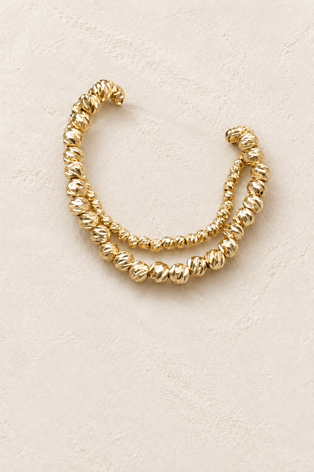 Gold Plated Double Textured Twin Bracelet Set on cream beige textured background