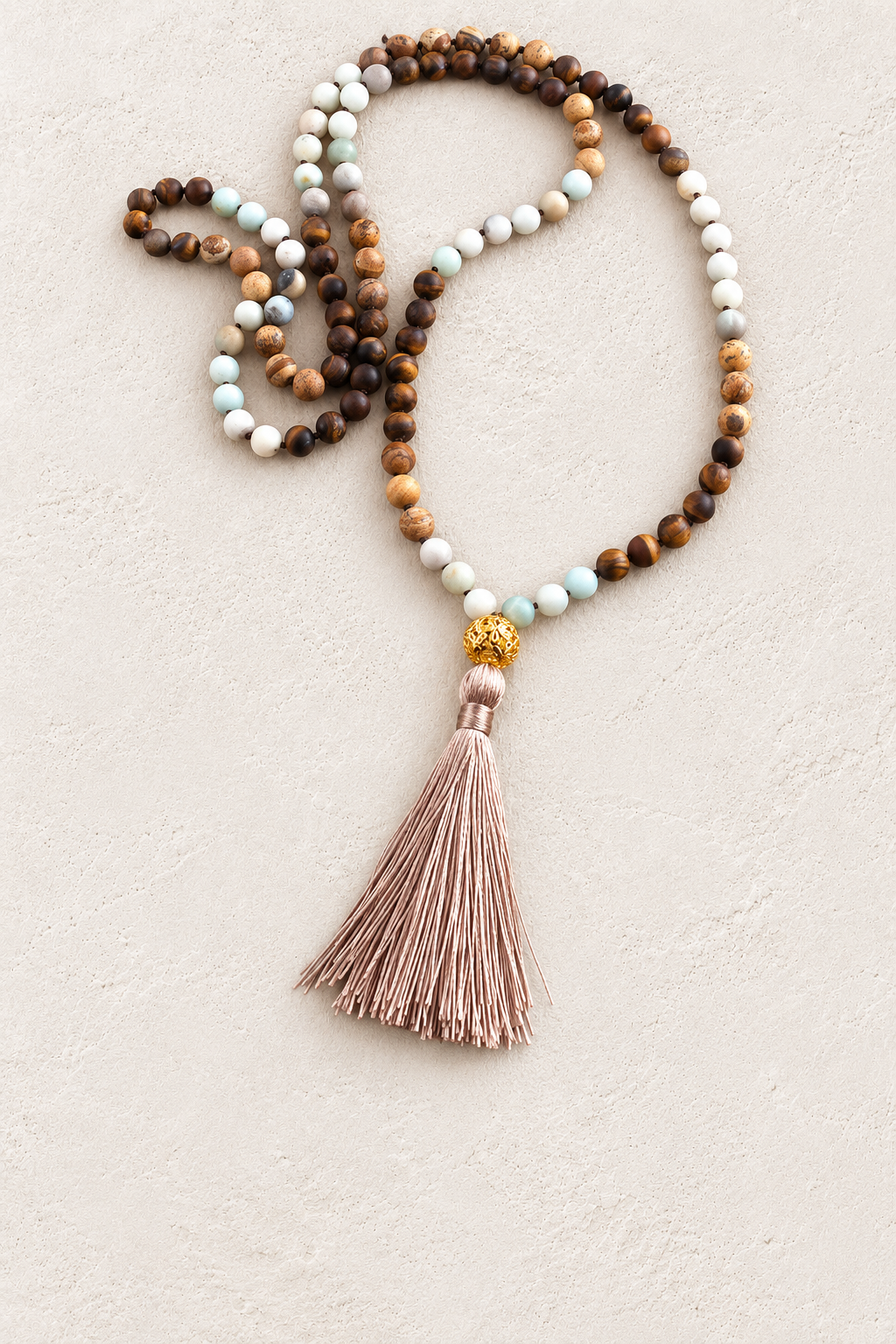 Earth Mala Necklace on warm ivory plaster background