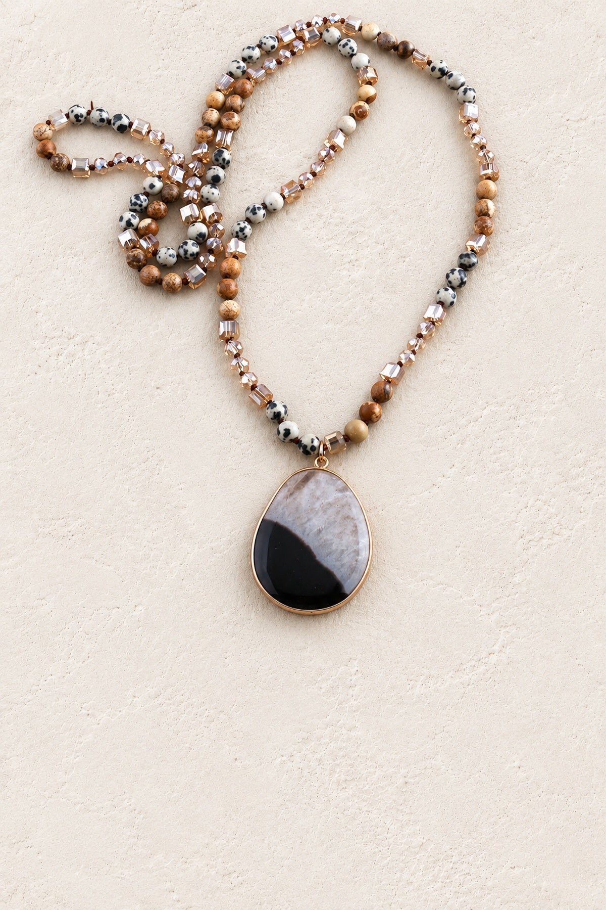 Earth Tones Tribal Stone Necklace on warm cream plaster background