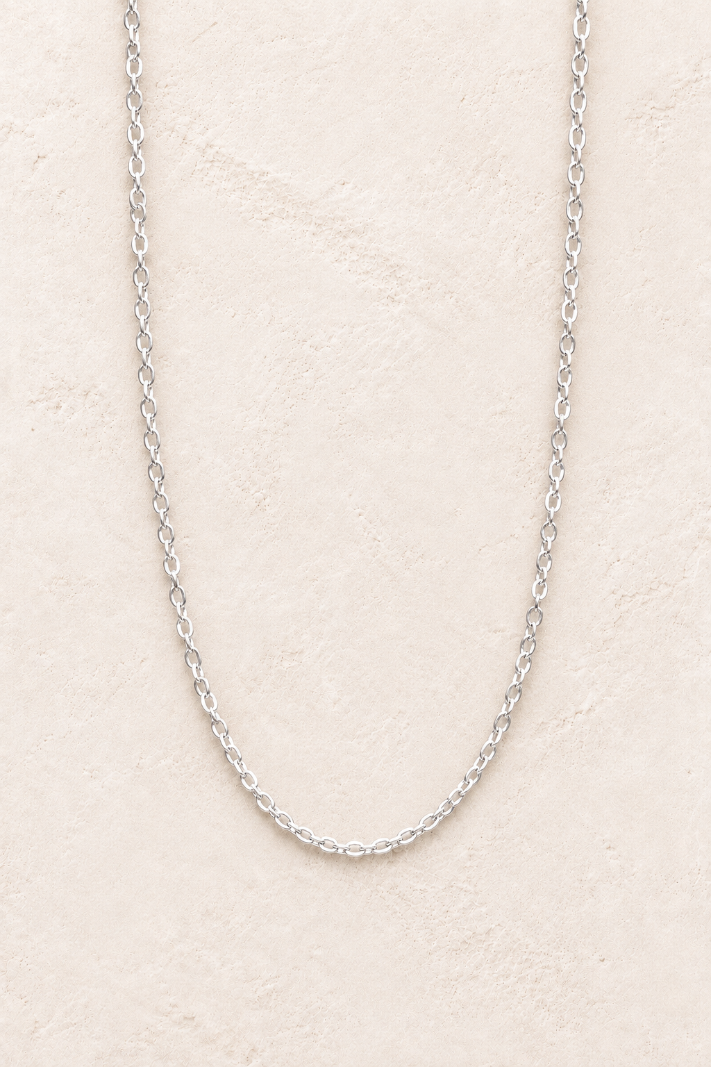 
                  
                    Elaria Silver Chain Necklace on warm ivory textured background
                  
                