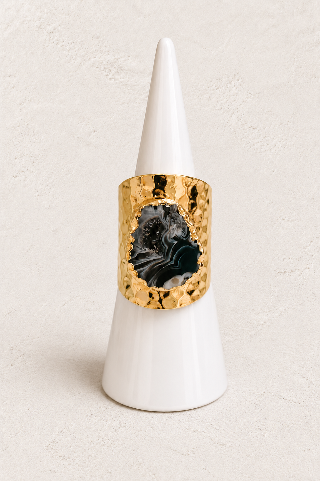 Elowyn Mini Grey Agate Geode Ring on white cone against warm textured background