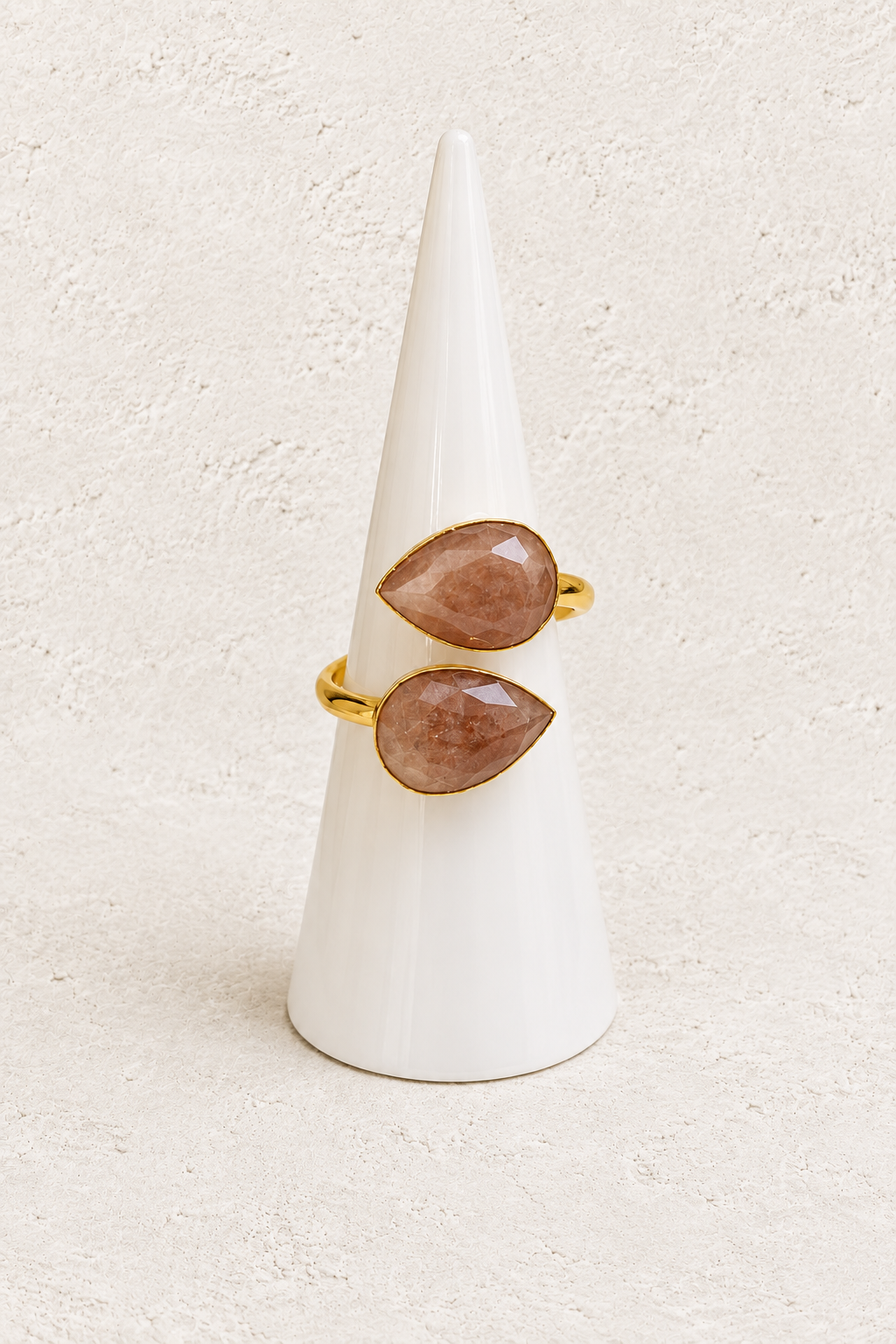 Esme Sunstone Adjustable Ring on white cone against warm textured background