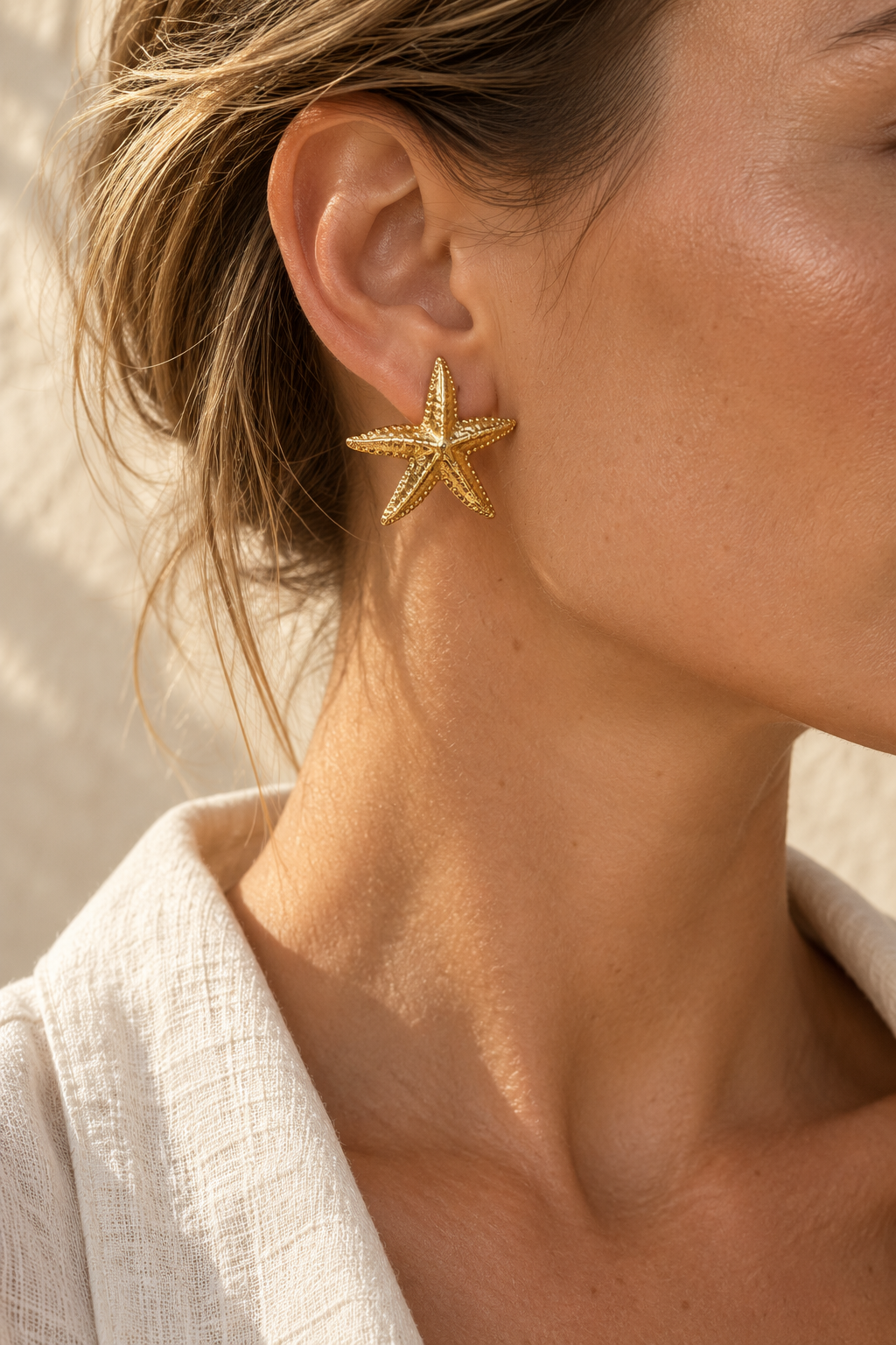 
                  
                    Model wearing Estelle gold starfish stud earring
                  
                
