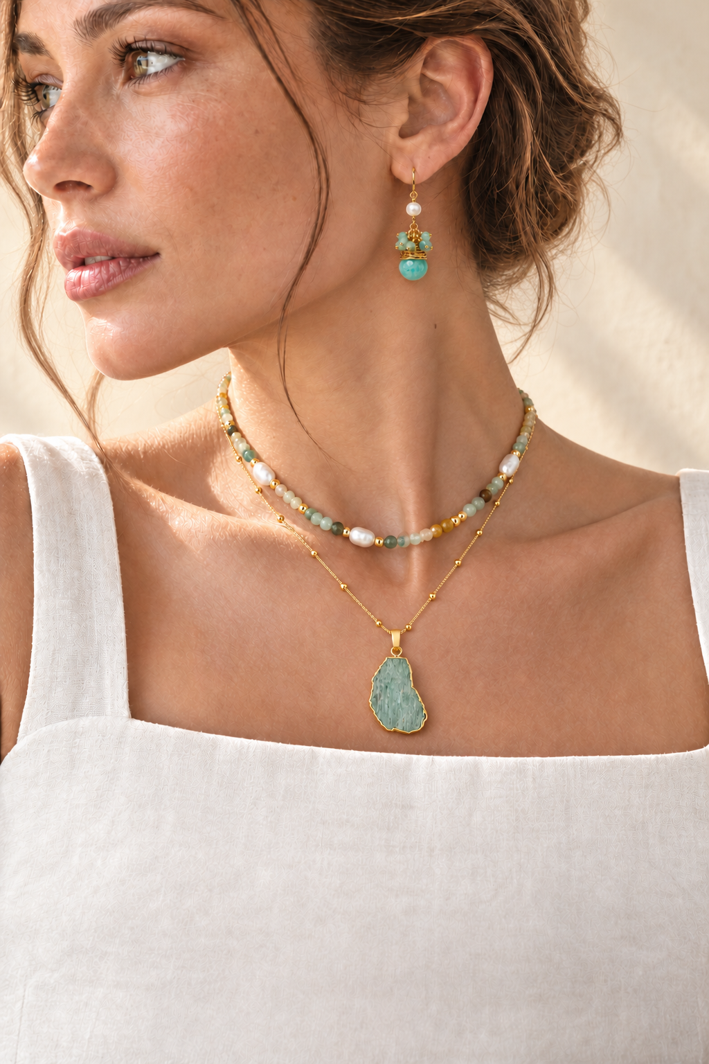 Model wearing a Boho & Mala amazonite pendant necklace, amazonite and freshwater pearl beaded necklace and amazonite drop earrings