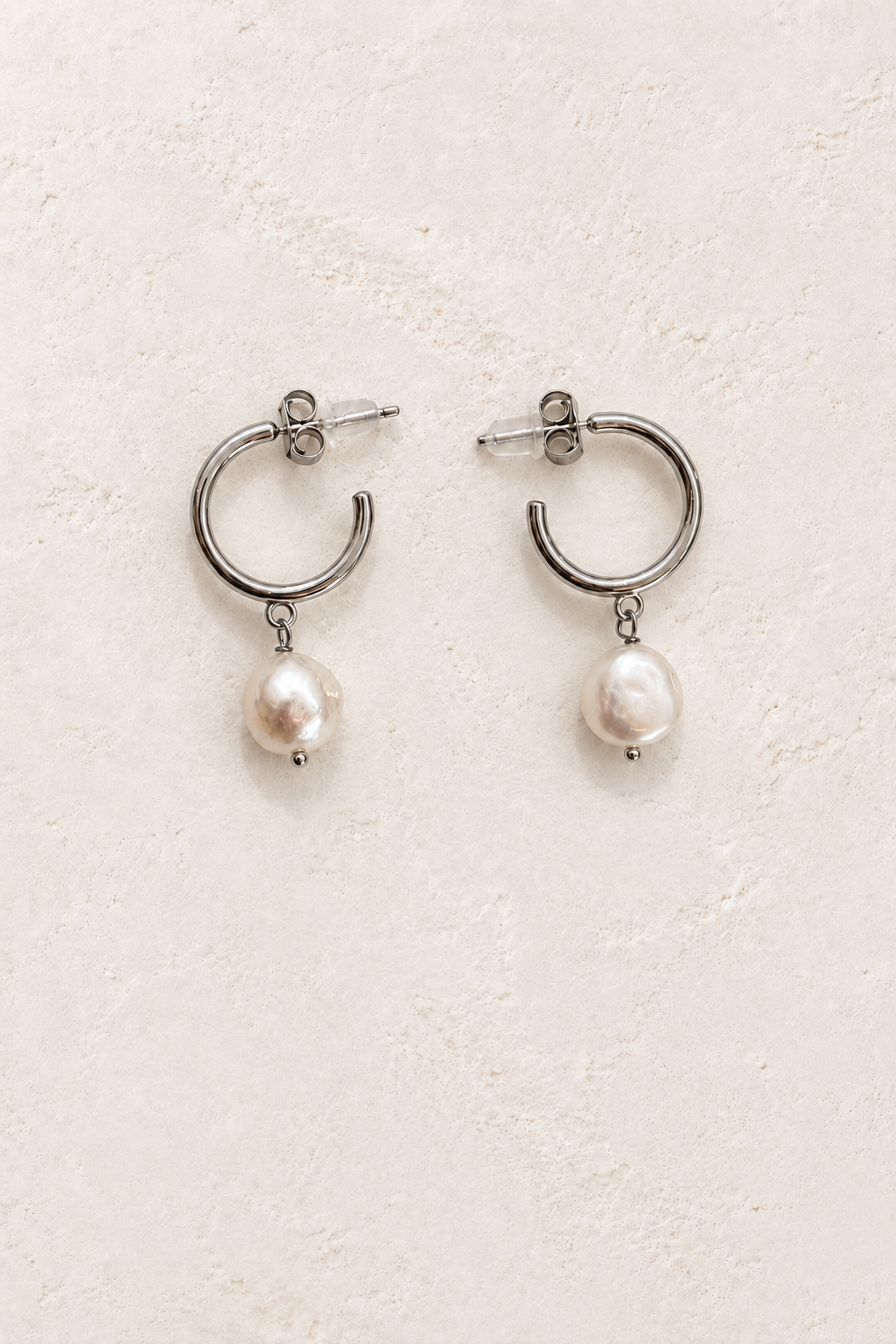 Florina Silver Pearl Drop Hoop Earrings on warm ivory plaster