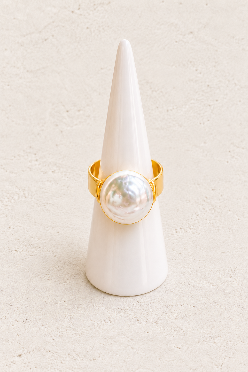 Roselle Freshwater Pearl Ring (Adjustable) on white cone against warm textured background
